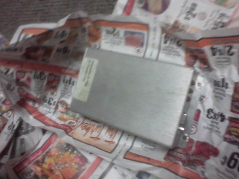 1995 Ford Probe - A metal electronic part is placed on top of a stack of newspapers.