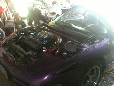 1995 Ford Probe - A purple car's engine bay is exposed, with other vehicles in the background.