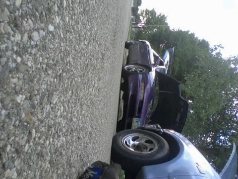 1995 Ford Probe - A purple 1995 Ford Probe is parked on a gravel surface with its hood and driver's side door open. The car is angled towards the viewer, wit…