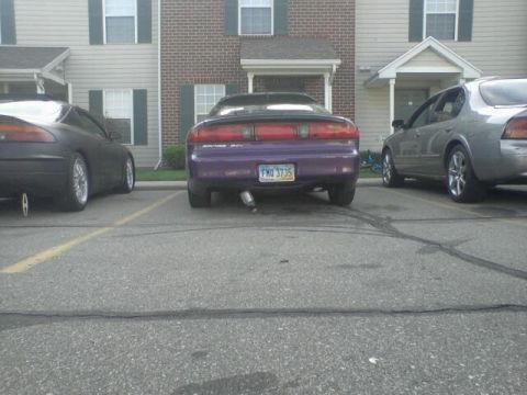 1995 Ford Probe - The rear of a purple 1995 Ford Probe is parked in a lot next to a silver sedan. The license plate reads "FMD 3735".