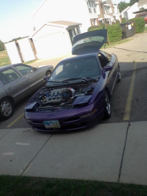1995 Ford Probe - A purple 1995 Ford Probe with its hood and trunk open is parked in a lot. The car has a license plate that reads "FMO 3735".
