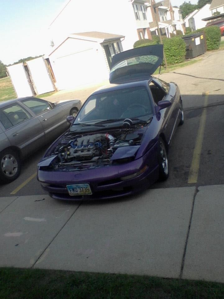 Purple 1995 Ford Probe with hood and trunk open, parked in a lot.