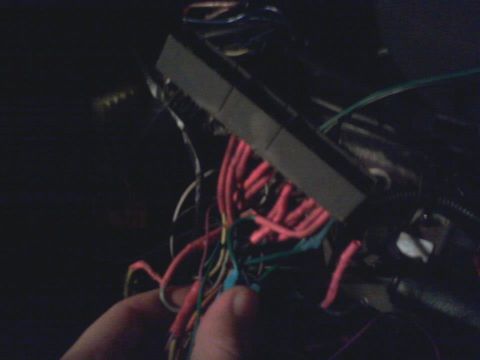 1995 Ford Probe - A close-up shot shows a hand holding a bundle of colorful wires connected to a gray electrical connector. The wires are red, green, yellow,…