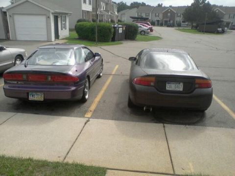 1995 Ford Probe - The rear view of a purple 1995 Ford Probe is parked next to a dark gray coupe in a parking lot. The purple Probe has a license plate that r…
