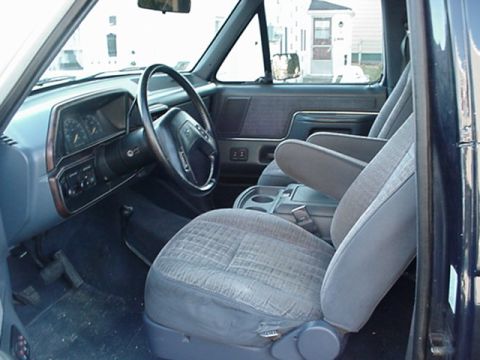 1993 Ford Bronco - The interior of a 1993 Ford Bronco features cloth seats, a dashboard with gauges, and a steering wheel.