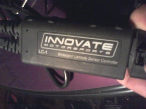 1995 Ford Probe - A close-up shot shows an Innovate Motorsports LC-1 Wideband Lambda Sensor Controller. The device is black with white text and labels, and i…
