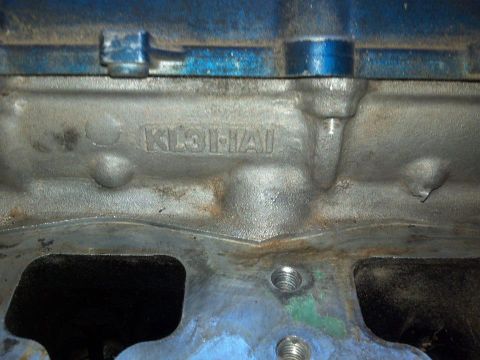 1995 Ford Probe - A close-up view of a cast metal engine block with the letters "KL3HAI" cast into its surface. The engine block is painted blue on the top e…