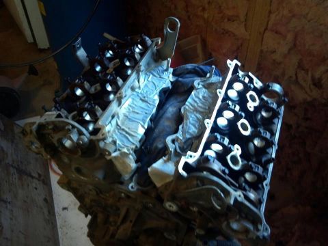 1995 Ford Probe - A disassembled engine block with valve covers is shown in a workshop setting. The engine appears to be a V-configuration with multiple cyli…