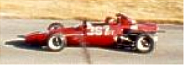 Red open-wheel formula race car, number 357, side view on track with driver aboard
