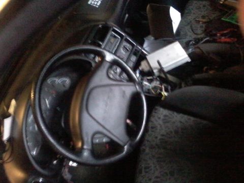 1995 Ford Probe - The interior of a car is shown, focusing on the steering wheel and dashboard. Wires and electronic components are visible in the center con…
