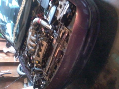 1995 Ford Probe - The engine bay of a purple 1995 Ford Probe is shown with the hood open, revealing the engine and various modifications. The intake manifold…