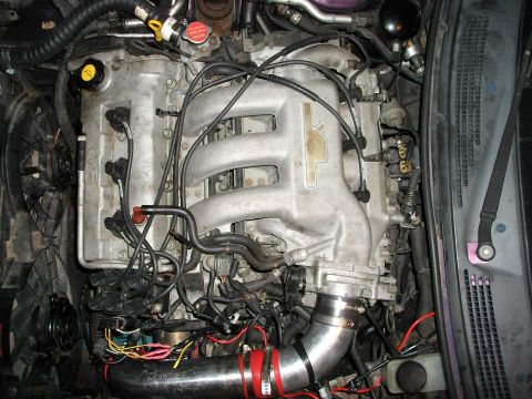 1995 Ford Probe - A close-up, overhead view of a modified engine bay, likely from a 1995 Ford Probe, showing the intake manifold, spark plug wires, and vario…