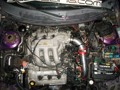 1995 Ford Probe - The engine bay of a modified 1995 Ford Probe, nicknamed "Starscream", is shown with custom purple accents and a prominent aftermarket intak…