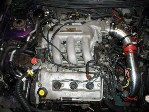 1995 Ford Probe - The engine bay of a 1995 Ford Probe, nicknamed "Starscream," is shown with various modifications including an aftermarket intake system and…
