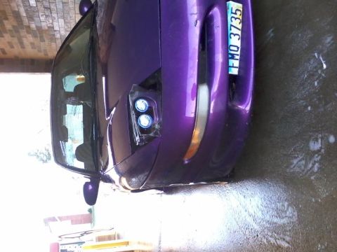 1995 Ford Probe - The front driver's side of a purple custom car is shown, with a license plate that reads "FMO 3735". The car has custom headlights with blu…