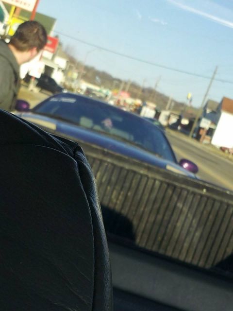 1995 Ford Probe - View from the interior of a vehicle looking at the bed of a pickup truck. A blue car with purple accents is visible in the background.