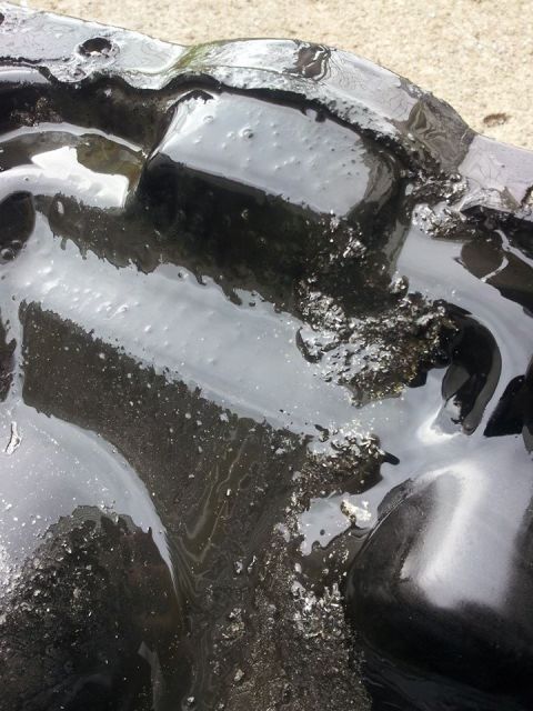 1995 Ford Probe - A close-up, abstract view of what appears to be a black, glossy car part, possibly a fender or bumper, with a textured, granular surface an…