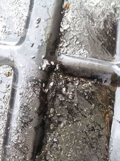 1995 Ford Probe - A close-up, abstract view of a tire tread with water and debris. The texture suggests a worn surface with embedded particles.