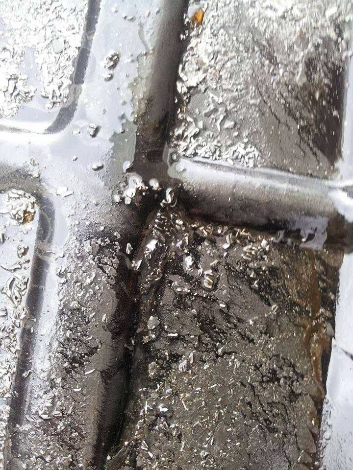 Close-up of tire tread with water and debris.