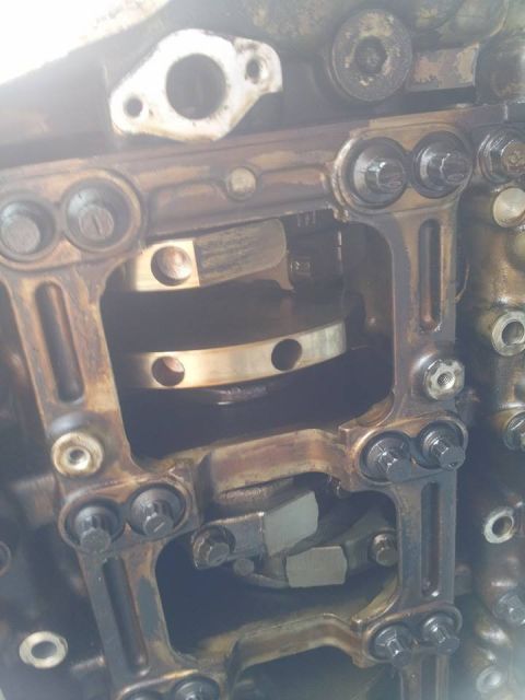 1995 Ford Probe - This is a close-up view of the internal components of an engine, likely a crankshaft and connecting rods, with visible oil and metal parts.
