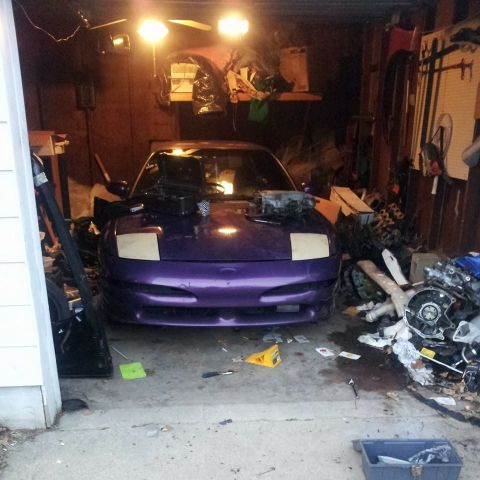 1995 Ford Probe - A purple Ford Probe is parked in a cluttered garage, with its hood open and engine components visible on the hood and in front of the car.…