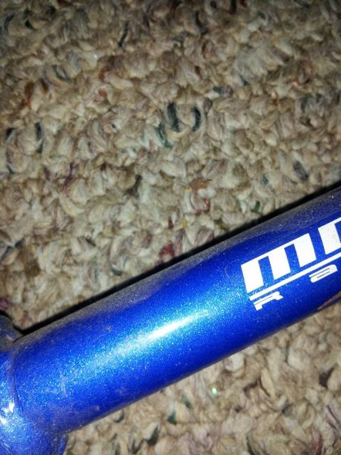 1995 Ford Probe - A close-up shot shows a metallic blue bicycle frame with white lettering that appears to be a brand logo. The frame is resting on a texture…