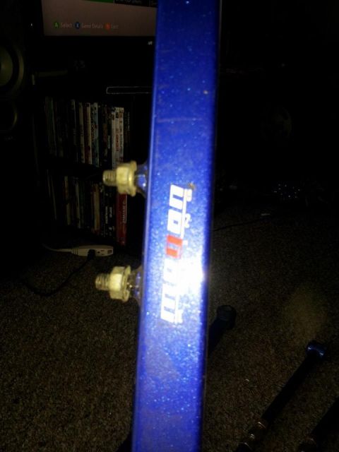 1995 Ford Probe - A close-up shot of a blue metallic painted metal bar with a "Mopar" logo on it. Two white nuts are visible on the side of the bar.