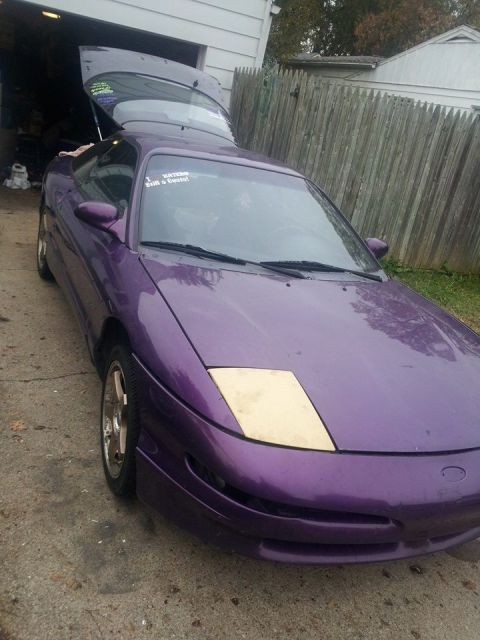 1995 Ford Probe - A purple 1995 Ford Probe with its trunk open is parked in a driveway next to a wooden fence. A sticker on the windshield reads "Haters Stil…