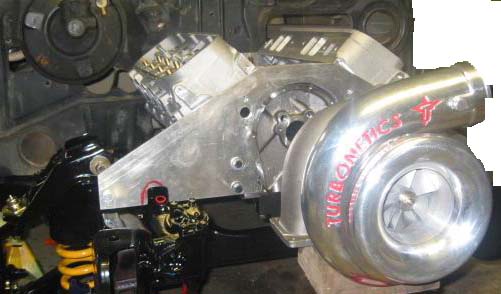 Turbonetics turbocharger on polished aluminum bracket mounted to the front of a V8 engine