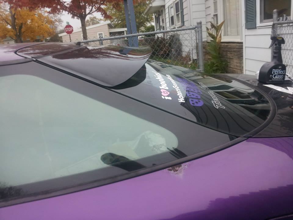 Purple 1995 Ford Probe rear passenger side with spoiler and stickers on window.