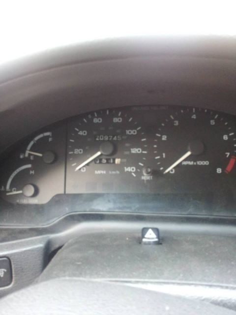 1995 Ford Probe - The image shows a close-up of a car's dashboard, focusing on the speedometer and tachometer. The odometer displays 209745 miles.