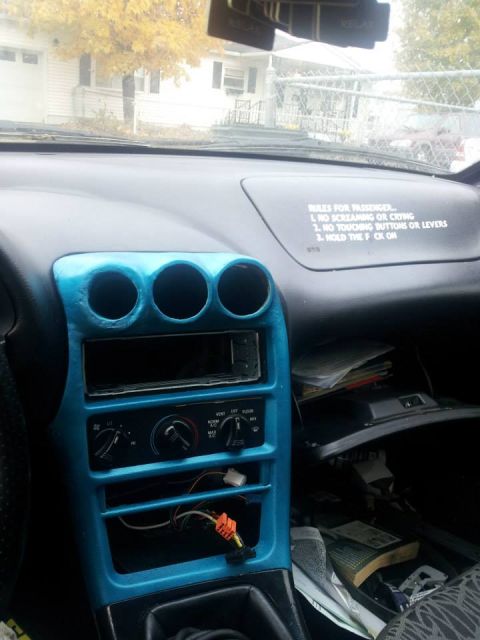 1995 Ford Probe - Interior view of a car dashboard with a blue-painted center console. A sticker on the dashboard reads "RULES FOR PASSENGER... 1. NO SCREAMI…