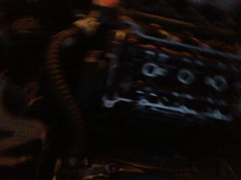 1995 Ford Probe - A close-up, blurry shot of what appears to be the engine bay of a vehicle, focusing on a dark, metallic component with circular openings.