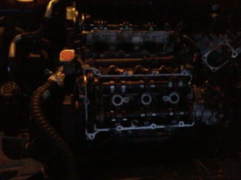 1995 Ford Probe - The image shows a close-up view of a disassembled engine, likely from a 1995 Ford Probe. The valve cover is removed, exposing the camshafts…