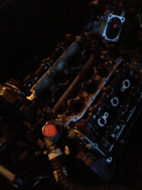 1995 Ford Probe - A close-up view of a disassembled engine, likely from a 1995 Ford Probe, showing internal components and a red radiator cap.
