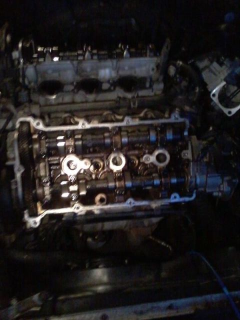 1995 Ford Probe - The image shows a disassembled internal combustion engine, likely from a 1995 Ford Probe. The cylinder head is removed, revealing the camsh…