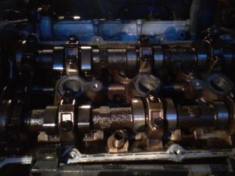 1995 Ford Probe - The image shows a close-up view of the camshafts and valve train components within an engine. The parts appear to be covered in oil and gri…