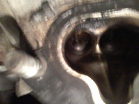 1995 Ford Probe - A close-up, blurry view of the inside of an engine cylinder head, showing a valve and carbon buildup.