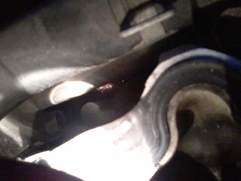 Close-up of dark mechanical part with red fluid