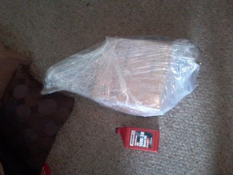 1995 Ford Probe - A red bottle of Spectrum 10W-30 Motor Oil sits on a carpeted floor next to a package wrapped in clear plastic.
