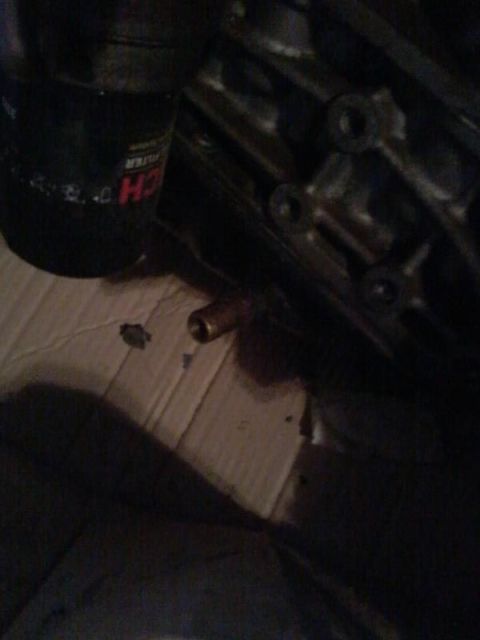 1995 Ford Probe - A close-up view shows a black oil filter with visible text and a brass fitting protruding from a dark metallic engine block. The scene appe…