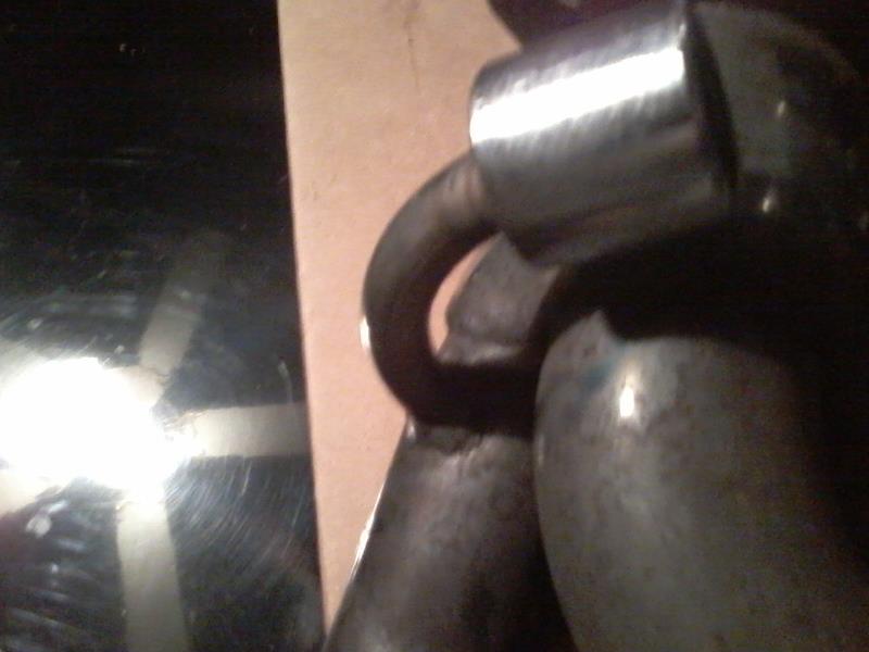 Close-up of a shiny curved metal part attached to a larger metal object.