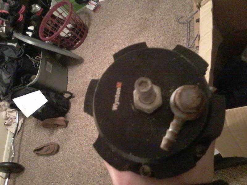 Black automotive part with "Wynton M" text and two fittings.