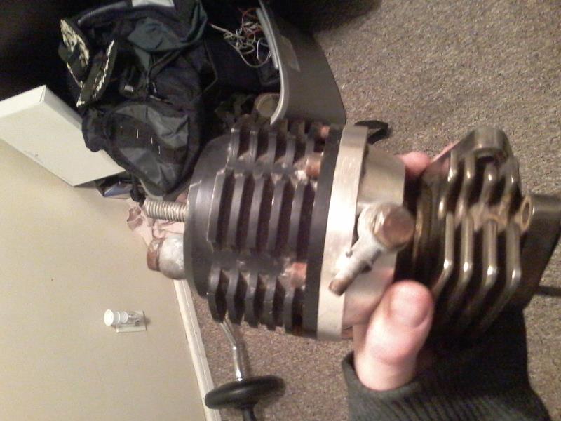 Modified turbocharger with fins held in a hand.