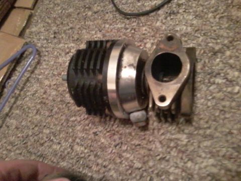 1995 Ford Probe - A turbocharger wastegate assembly is shown resting on a carpeted surface. The assembly features a black, finned actuator and a metallic fla…