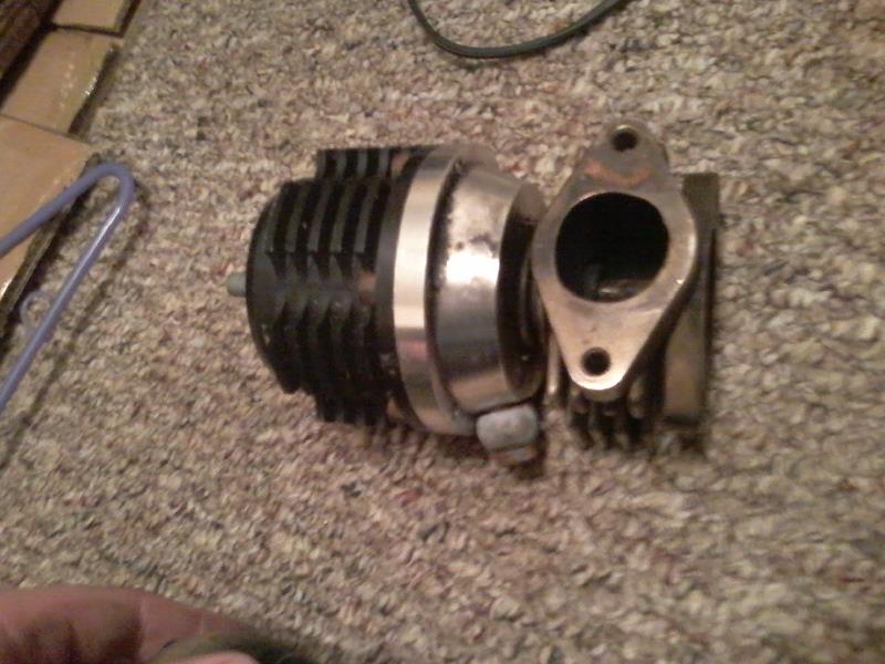 Turbocharger wastegate assembly with black finned actuator and metallic flange.