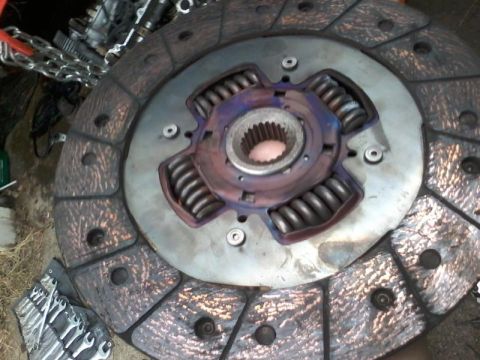 1995 Ford Probe - A close-up view of a car clutch disc with visible springs and a splined hub. The friction material shows signs of wear and heat discolorati…