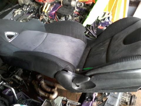 1995 Ford Probe - A close-up view of a pair of racing seats, likely for a car, is shown in a cluttered garage setting. The seats are black and grey with ribb…