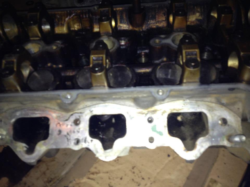 Close-up of a dirty engine intake manifold and valve train.