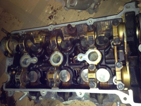 1995 Ford Probe - This is a close-up, overhead view of the internal components of an engine, likely a cylinder head. The metal parts are covered in oil and g…